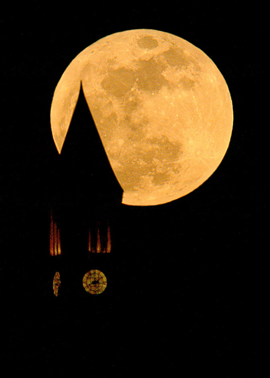 Cornell's clock tower silhouetted against the rising full moon