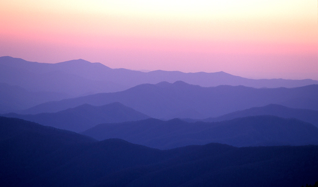 Bluish violet mountains under a reddish-yellow sky in Smoky Mountain National Park
