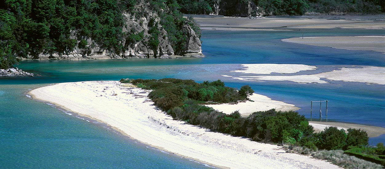 view of Torrent Bay, South Island, NZ showing light sand bars and blue-green water