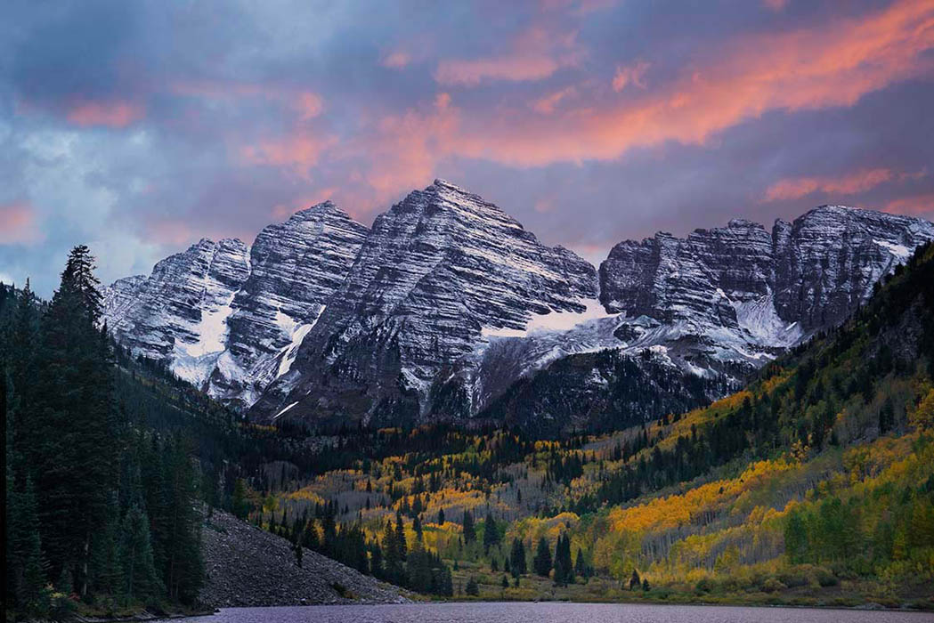 Maroon Bells with light snow cover and nearby golden foliage